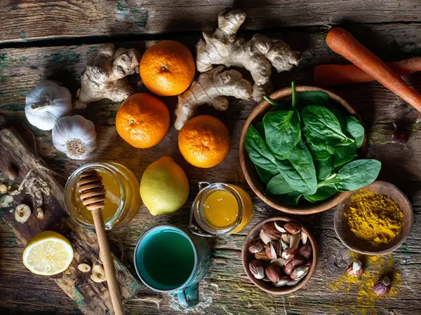 Alimentos naturais que fortalecem a imunidade, como alho, gengibre, frutas cítricas, iogurte e cúrcuma.